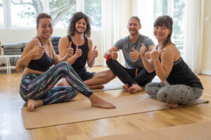 Smiling Yoga Students Showing Thumbs Up